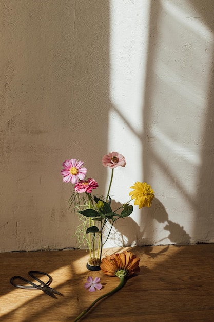 Natura morta autunnale Composizione di fiori autunnali e forbici alla luce del sole in una moderna sala rustica