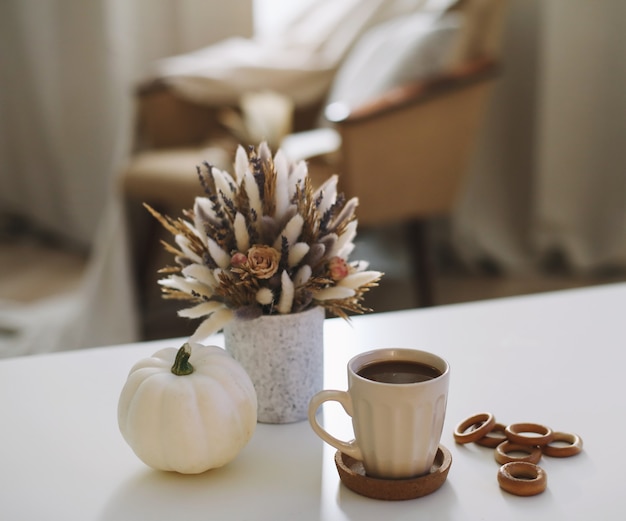 Natura morta autunnale con una tazza di caffè fiori libro e zucca Hygge lifestyle accogliente atmosfera autunnale