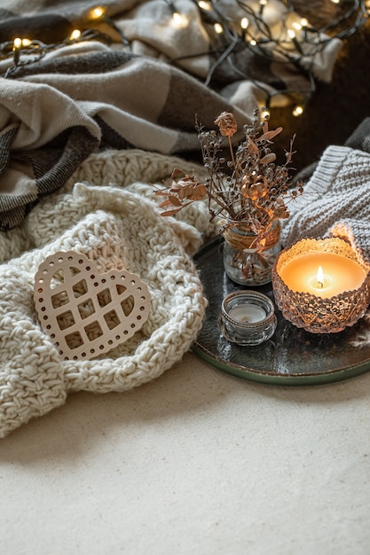 Natura morta con candele in candelieri, dettagli decorativi e oggetti a maglia. Il concetto di San Valentino e decorazioni per la casa.