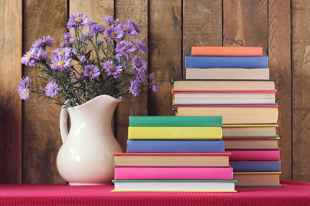 Natura morta con libri e un bouquet autunnale contro tavole.