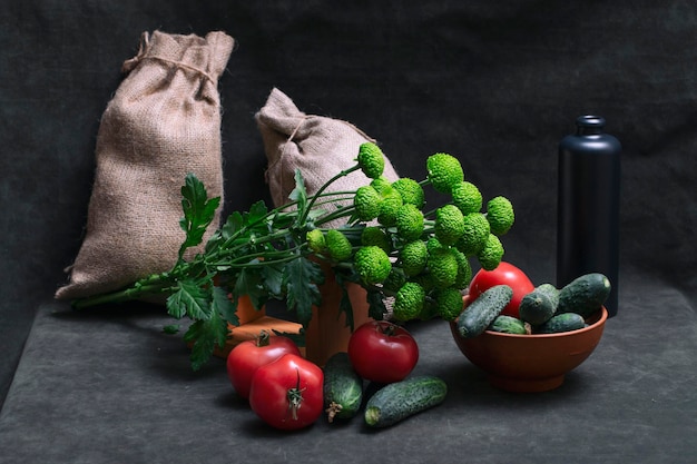 Natura morta con pomodori cetrioli e un bouquet di crisantemi