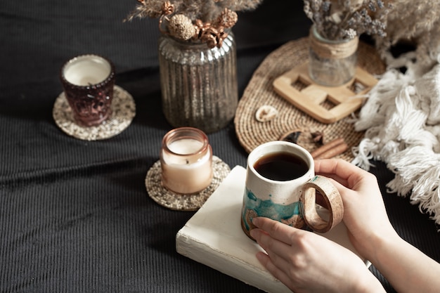 Natura morta con una bella tazza e mani femminili.