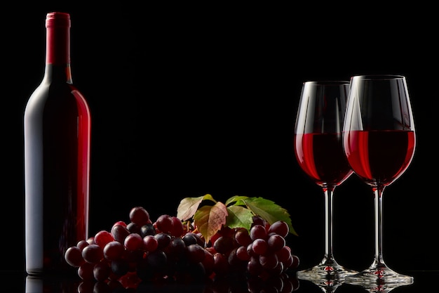 Natura morta con una bottiglia di vino rosso, bicchieri e uva.