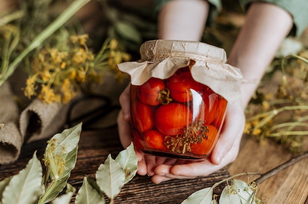 Natura morta con una lattina di pomodori in scatola tra condimenti ed erbe aromatiche.