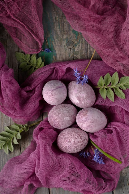 Natura morta di belle uova viola con consistenza su garza viola