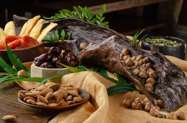 Natura morta di noci e frutta secca su un tavolo di legno con foglie di felce