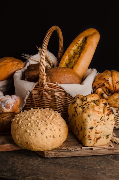 Natura morta di un assortimento vario di pane su una parete nera