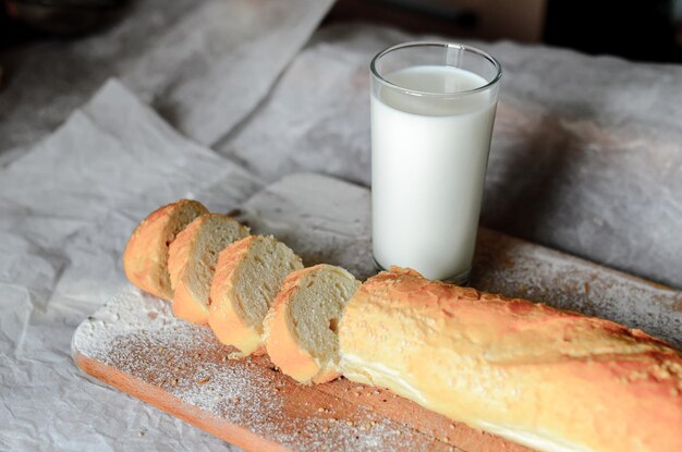 Natura morta di un bicchiere di latte e fette di pane