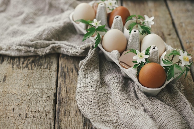 Natura morta rustica di Pasqua Uova di pasqua naturali con fiori primaverili in fiore nel vassoio su legno rurale