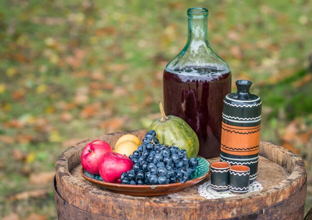 Natura morta su botte di rovere di frutta e vino rosso autunno