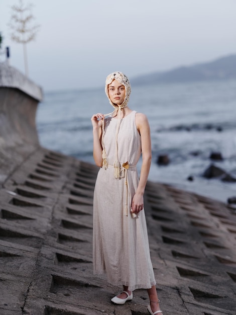 Natures glamour una giovane e attraente modella femminile che posa su una pietra sulla spiaggia trasuda eleganza e stile