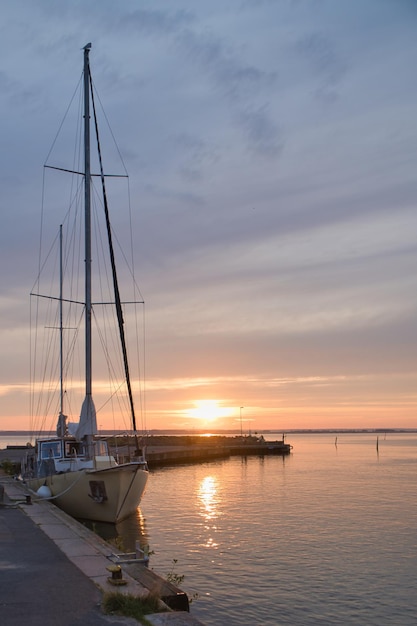 Nave a vela nel porto del lago Vaetten al tramonto Faro sullo sfondo