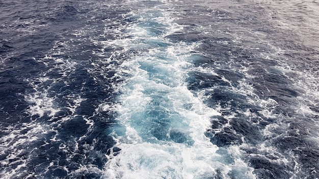 Nave da crociera o sentiero sulla superficie del Mar Rosso Blu. Traccia della nave dell'acqua di mare con l'onda schiumosa bianca Vista dall'alto dell'oceano profondo. Prospettiva di un'onda di acqua bianca.