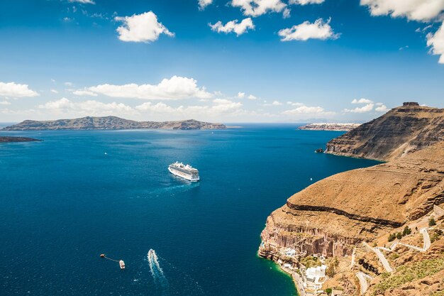 Nave da crociera vicino alle isole greche. Mare turchese brillante e cielo blu. Isola di Santorini, Grecia