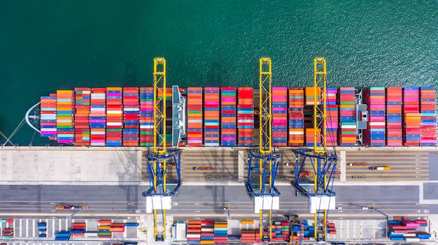 Nave porta-container che carica e che scarica nel porto marittimo profondo, vista superiore aerea dell'importazione e dell'esportazione logistiche di affari