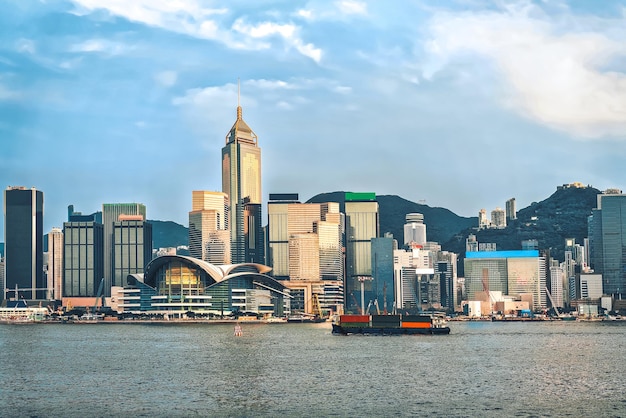 Nave portacontainer al porto di Victoria di Hong Kong al tramonto. Vista da Kowloon sull'isola di Hong Kong.