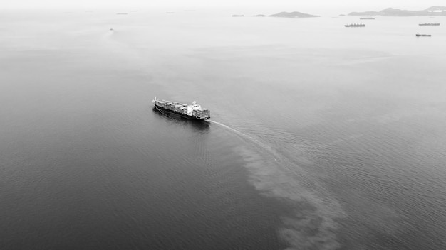 Nave portacontainer in bianco e nero che naviga in acque profonde