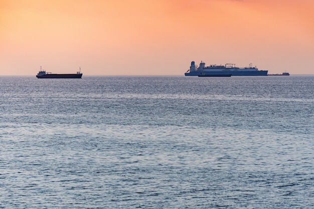 Navi da carico e chiatta al bellissimo tramonto