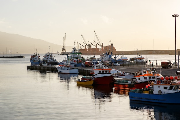 Navi e barche nel porto marittimo sul tramonto.