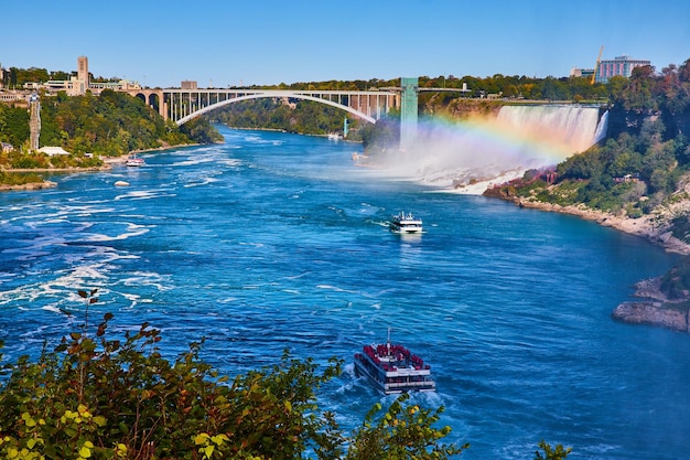 Navi turistiche sul fiume Niagara con arcobaleno e avvicinando Rainbow Bridge e American Falls