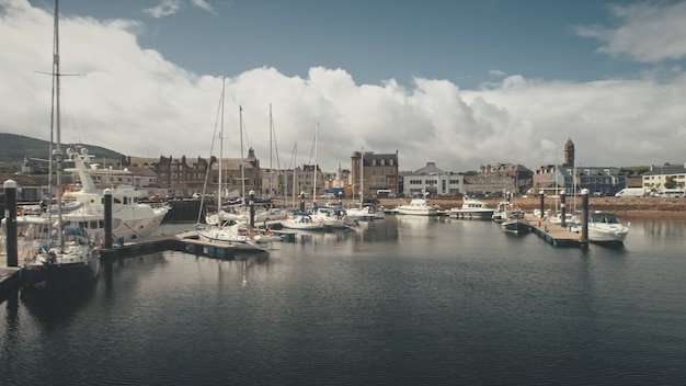 Navi yacht al paesaggio urbano aereo della baia dell'oceano con punto di riferimento di architettura moderna e storica al porto