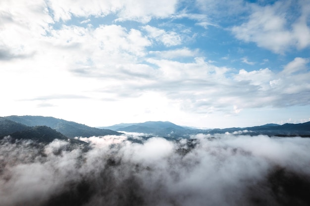 Nebbia con montagne e luce al mattino