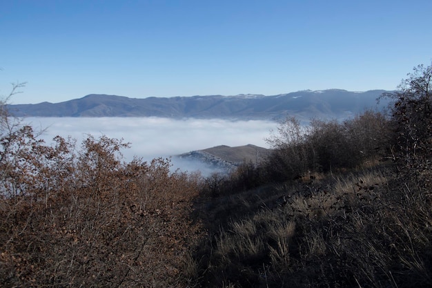 Nebbia e nuvole sopra l'alta montagna