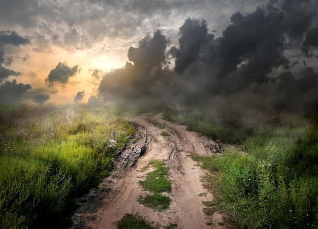 Nebbia e sporcizia sulla strada di campagna al tramonto