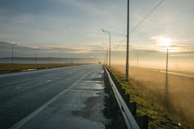 Nebbia sulla strada lungo il campo all'alba nebbia nel campo autunnale lungo l'autostrada Ulyanovsk