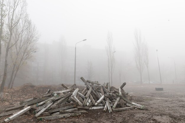 Nebbiosa mattina d'autunno in città. Concetto ecologico. Nebbia profonda sulla strada della città nella fredda e buia mattina d'autunno. Discarica di strutture in cemento per le strade