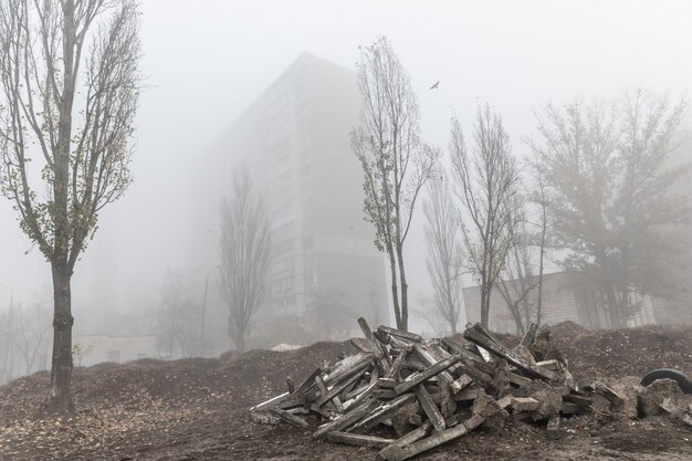 Nebbiosa mattina d'autunno in città. Concetto ecologico. Nebbia profonda sulla strada della città nella fredda e buia mattina d'autunno. Discarica di strutture in cemento per le strade