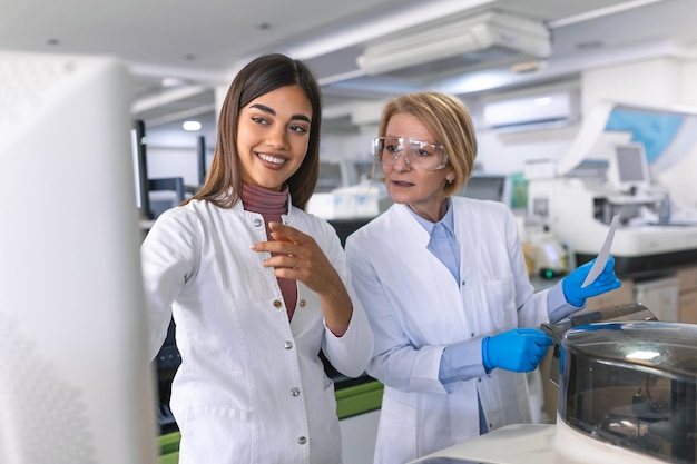 Nel laboratorio biotecnologico la ricercatrice femminile analizza la provetta nella macchina medica funziona con campioni di materiale genetico del sangue