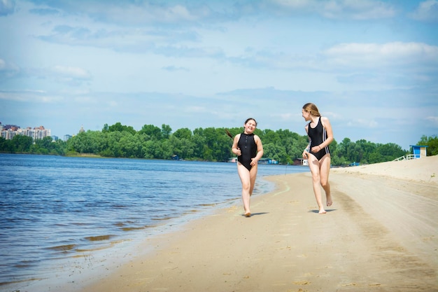 Nel pomeriggio d'estate sulla spiaggia due amiche giocano sulle rive del fiume