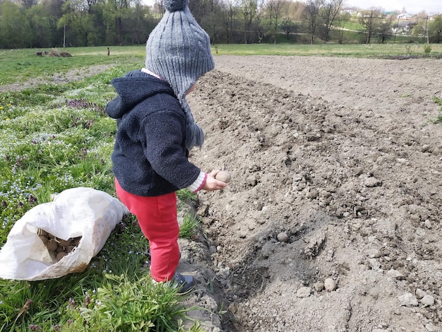 Nel villaggio sul campo una ragazza pianta patate con la madre