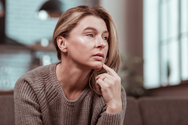 Nella disperazione. Donna matura dai capelli biondi depressa che si sente disperata dopo aver litigato con il marito