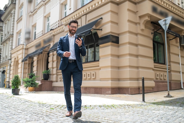 Nella strada. Giovane bello in un vestito che cammina per strada