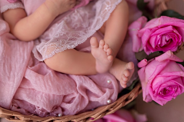 Neonata che dorme nel cestino retrò con fiori di rose da giardino rosa