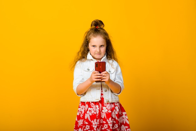 Neonata felice con il telefono isolato su giallo