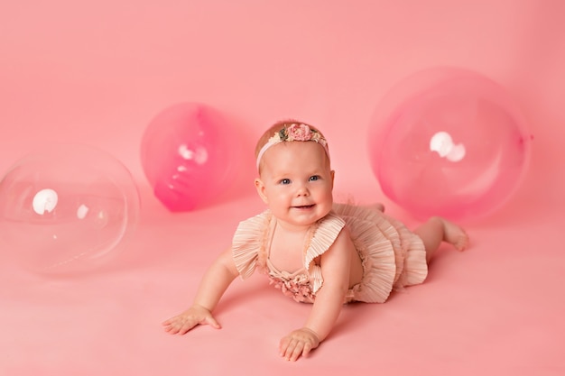 Neonata felice con palloncini rosa. Celebrazione. Compleanno.