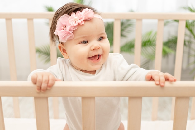 Neonata felice sei mesi in piedi nel presepe