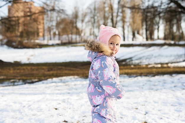 Neonata in tuta da neve invernale in una giornata di sole