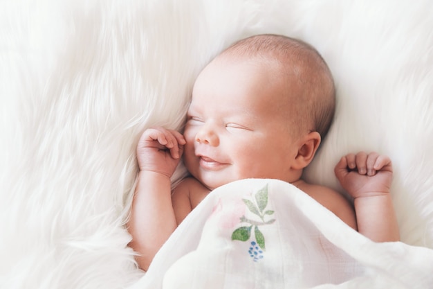 Neonato addormentato avvolto in una coperta bianca bambina di 7 giorni di una settimana