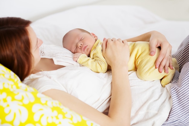 Neonato addormentato nelle mani della madre