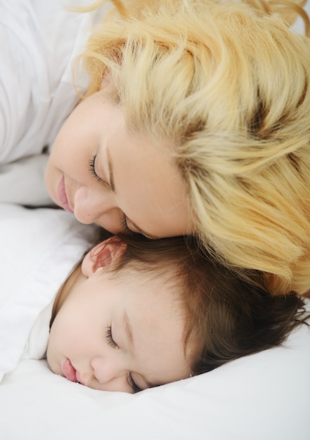 Neonato adorabile con la mamma sul letto