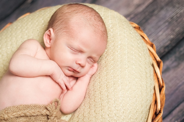 Neonato che dorme con la mano sotto la guancia