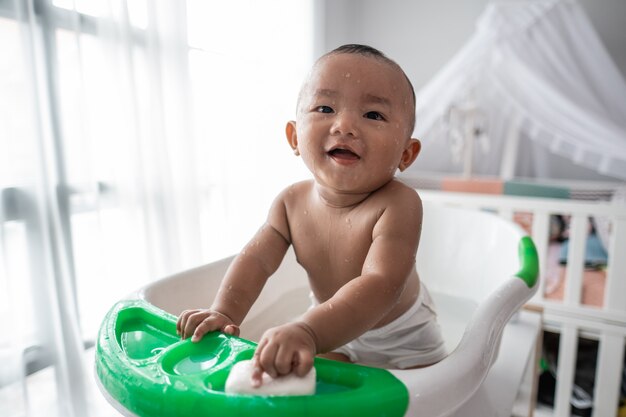 Neonato che fa un bagno che si siede su un bacino