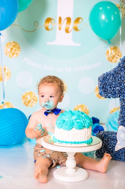 Neonato che gioca con una torta durante la festa di compleanno di smash torta