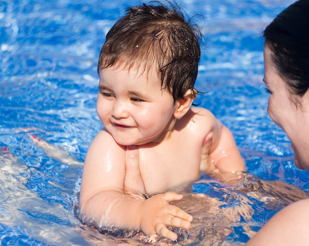 Neonato che gioca in piscina con sua madre