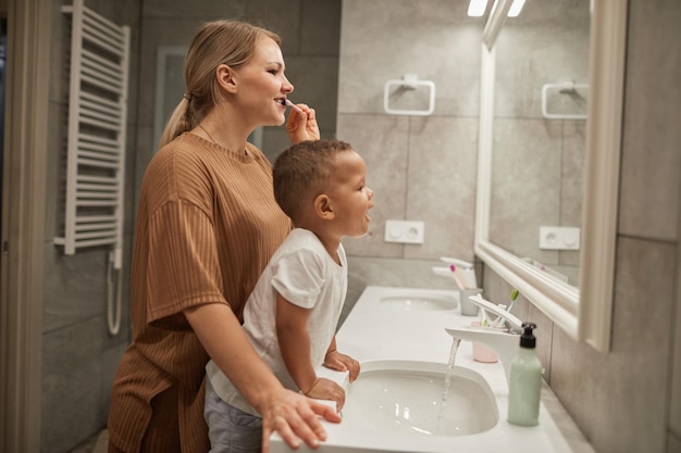 Neonato che si lava i denti con la mamma