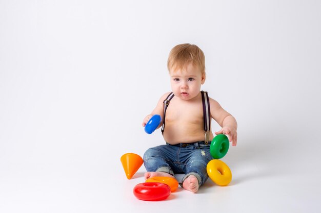 Neonato del bambino con il giocattolo su fondo bianco